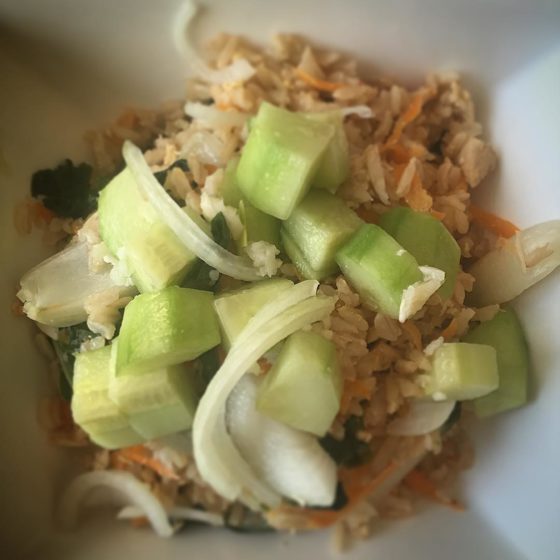 On the menu tonight: spicy chicken and veggie fried rice topped with a fresh cucumber and onion salad.
